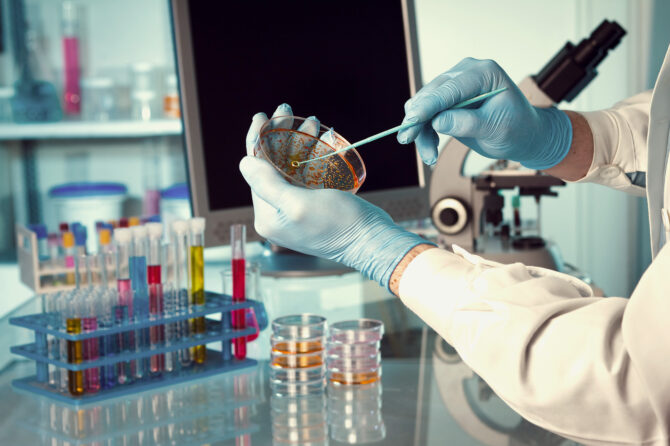 Scientist working with tools and specimens in a high tech lab.