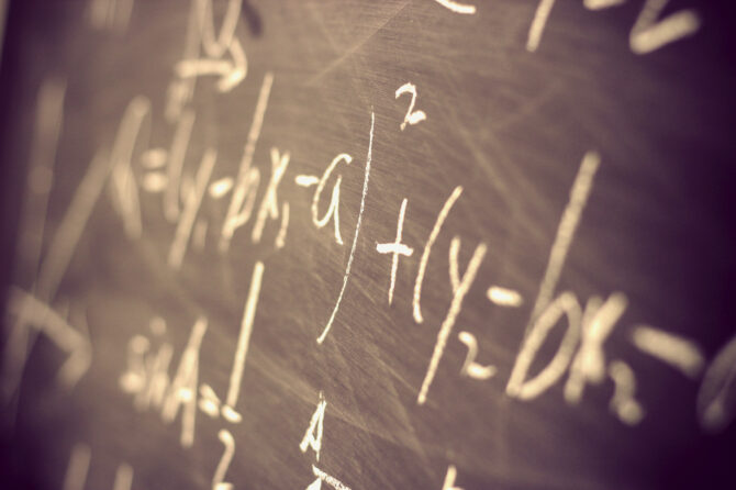 Chalkboard with mathematical equations written on it.