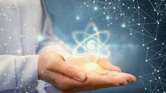 Nuclear symbol of an atom held in a person's outstretched hands.