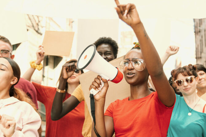 Group of young people leading a demonstration for social justice.