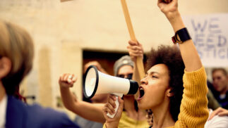 Young person with a bullhorn at a demonstration.