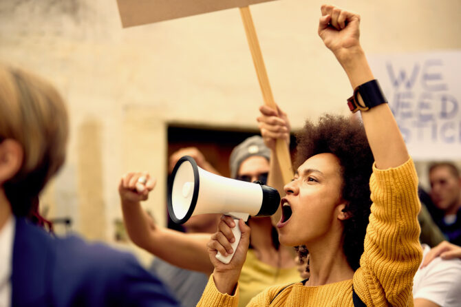 Young person with a bullhorn at a demonstration.