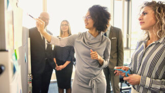 Group of executives reviewing a presentation in a meeting room.