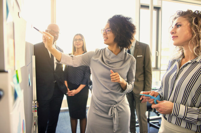 Group of executives reviewing a presentation in a meeting room.