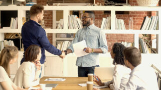 Young professionals closing a financial deal with a handshake.