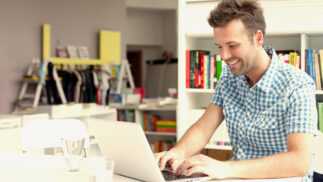 Person working on a notebook computer in an informal office.