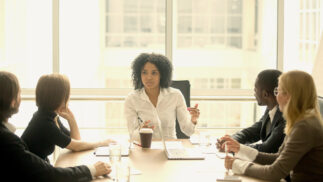 Young executive leading a team at a board room table.