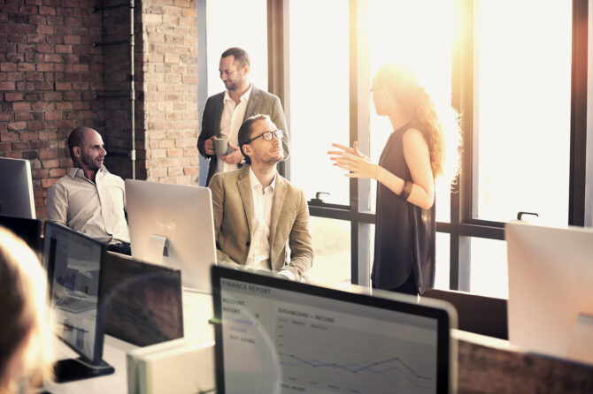 Team of four people in business discussions in an office.