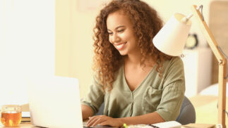 A woman working at a laptop.