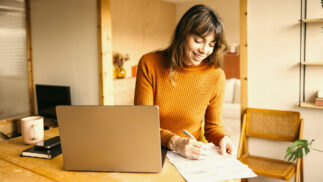 A woman working at a laptop.