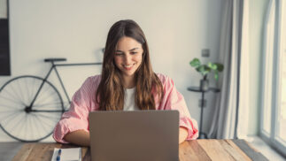 A woman working at a laptop.