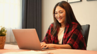 A woman working at a laptop.