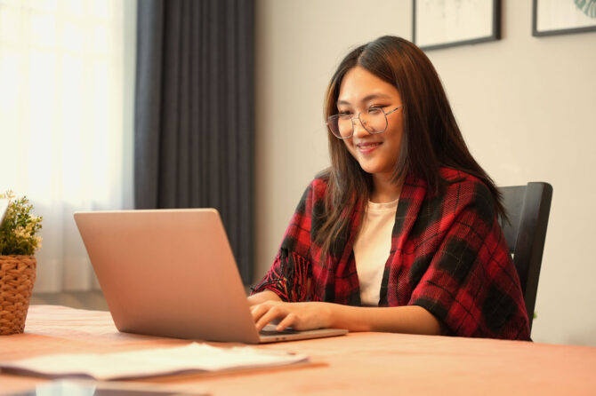 A woman working at a laptop.
